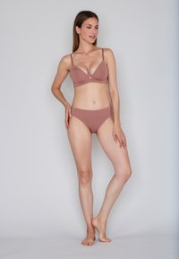 Set di reggiseno e bikini in un caldo colore mauve, caratterizzato da un materiale morbido, un design minimalista, spalline sottili e copertura moderata.