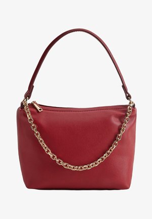 Bolso de mano de cuero rojo con asa superior y cadena decorativa dorada en el frente, con cierre de cremallera en la parte superior.