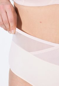 Mutande alta in rosa chiaro con cintura in rete e design senza cuciture, che sottolineano morbidezza e comfort.