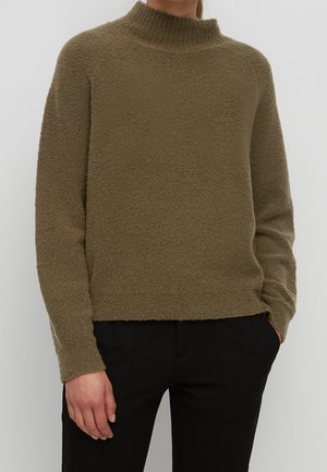 Maglione verde oliva, con texture, colletto alto, spalle cadenti e vestibilità comoda. Il tessuto lavorato mostra una superficie morbida e pelosa.