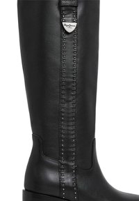Bota de cuero negra hasta la rodilla con un acabado suave, que presenta un detalle vertical de tachuelas y un acento metálico con el logo.