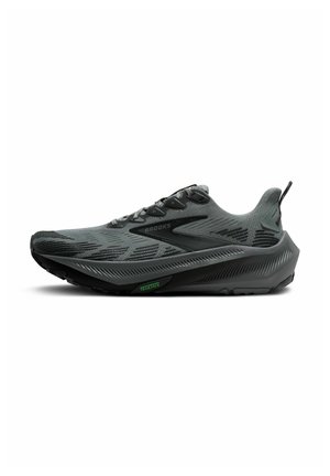 Brooks running shoe in dark gray with a textured upper, reflective accents, and a cushioned sole featuring a green "TRAILTACK" detail.