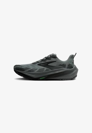 Brooks running shoe in dark gray with a textured upper, reflective accents, and a cushioned sole featuring a green "TRAILTACK" detail.
