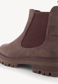Bottine Chelsea en cuir marron avec panneau latéral élastique, languette de tirage, détails cousus et semelle crantée avec petit talon empilé.
