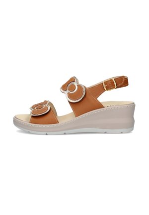 Sandalo con zeppa marrone con suola beige, due cinturini regolabili con toppe decorative circolari e cinturino alla caviglia con fibbia dorata.