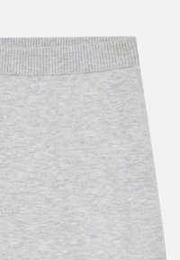 Ljusgrå tröja med ribbad halsringning. Mjukt, texturerat tyg med ett subtilt melerat mönster. Enkel, klassisk design utan ytterligare detaljer.