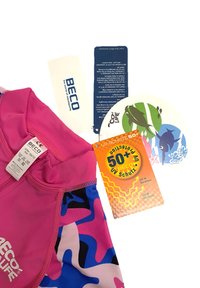 T-shirt de bain à manches courtes en rose vif avec des motifs abstraits bleus et noirs. Comprend des étiquettes de protection UV et des détails d'étiquettes.