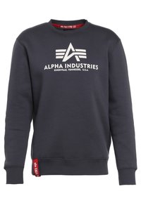Felpa grigio scuro in cotone misto con polsini e orlo a coste. Presenta il logo bianco "Alpha Industries" e un'etichetta rossa.