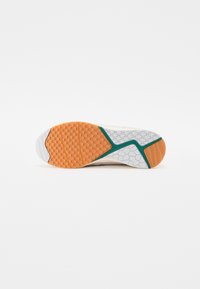Suola di una sneaker con un motivo esagonale, caratterizzata da accenti arancioni, bianchi e verdi. Materiale in gomma resistente con grip testurizzato.