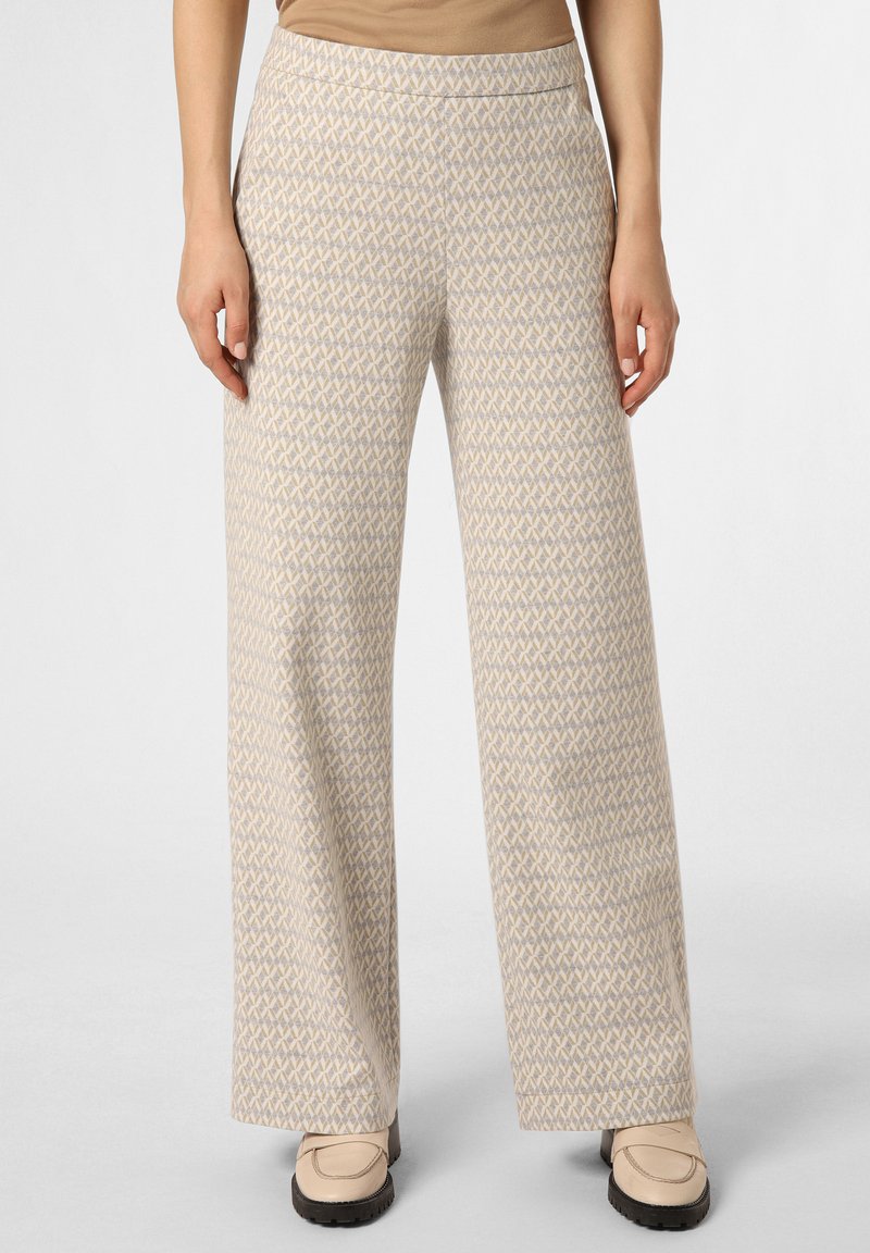 Light beige wide-leg pants with geometric pattern, crafted from soft fabric. Features a flat waistband and side pockets. Styled with beige slip-on footwear.