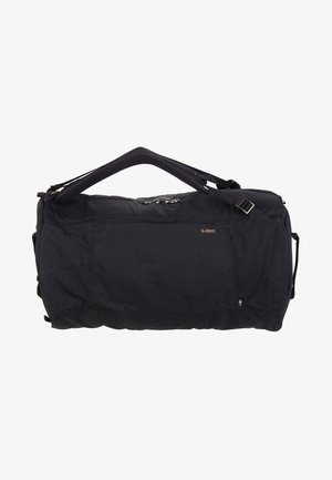 Schwarze Duffle-Tasche aus strapazierfähigem Stoff mit einem Oberhandgriff und einem verstellbaren Schultergurt. Enthält eine Vordertasche und Markenhinweise.