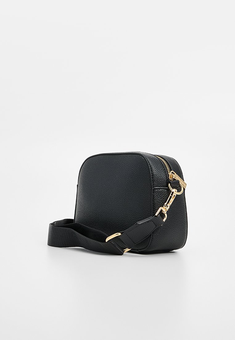 Sac bandoulière noir en simili cuir, forme rectangulaire, surface texturée, fermoir à glissière dorée, sangle réglable, design minimaliste.