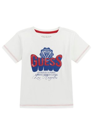 Hvid bomulds t-shirt med et fremtrædende rødt og blåt "GUESS" logo i et badges design. Inkluderer dekorativ rød syning på ærmerne.