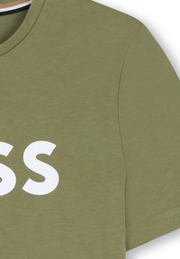 Olive green cotton t-shirt with short sleeves and a crew neckline. Features large white printed text across the front. Simple, smooth texture.