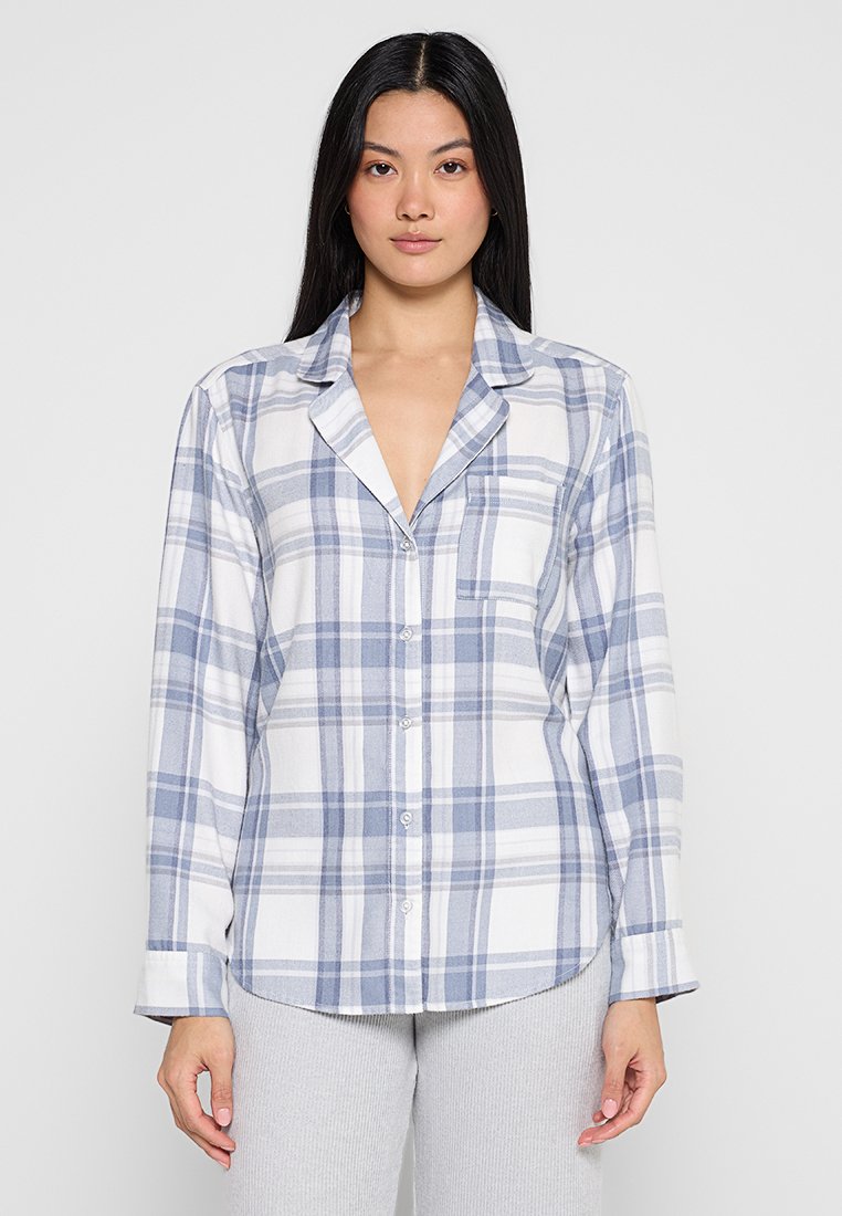 Kariertes Button-up-Hemd in Weiß und Hellblau, aus weichem Stoff, mit langen Ärmeln, einem Kragen und einer einzelnen Brusttasche.