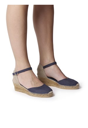 Navy canvas wedge espadrilles with a jute rope sole and ankle strap, featuring a rounded toe and open sides for breathability.