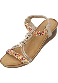 Beige Keilabsatzsandalen mit geflochtenen, mehrfarbigen Riemen, floralen Akzenten und dekorativen Perlen. Glatter Fußbett und strukturierte Sohle.