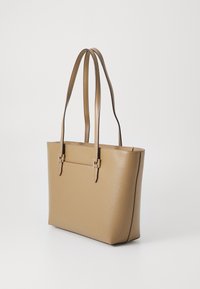 Tan faux leather tote bag with two long handles, rectangular shape, subtle texture, and a minimalistic design featuring buckle accents.