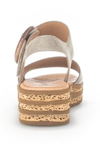 Beige platform sandál s korkovou podrážkou, se třemi texturovanými pásky a zaobleným, dekorativním knoflíkem na zadním pásku.