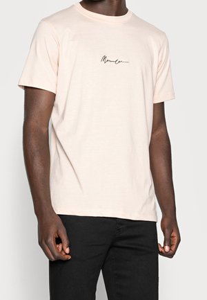 Jasnoróżowa bawełniana koszulka z okrągłym dekoltem, krótkimi rękawami i czarnym logo na piersi. Luźny krój.