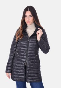 Giacca nera imbottita con zip frontale, colletto alto e design a righe orizzontali. Presenta due tasche laterali con chiusure a zip.
