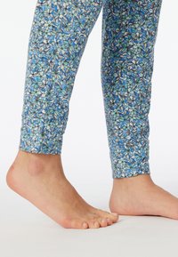 Blauwe bloemenlegging heeft een kleurrijk patroon met bloesems in tinten blauw en groen, gemaakt van een zachte, rekbare stof.