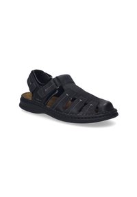 Black leather sandal with open design, featuring cutouts, contrasting stitching, adjustable strap, and a cushioned insole. Flat rubber outsole.