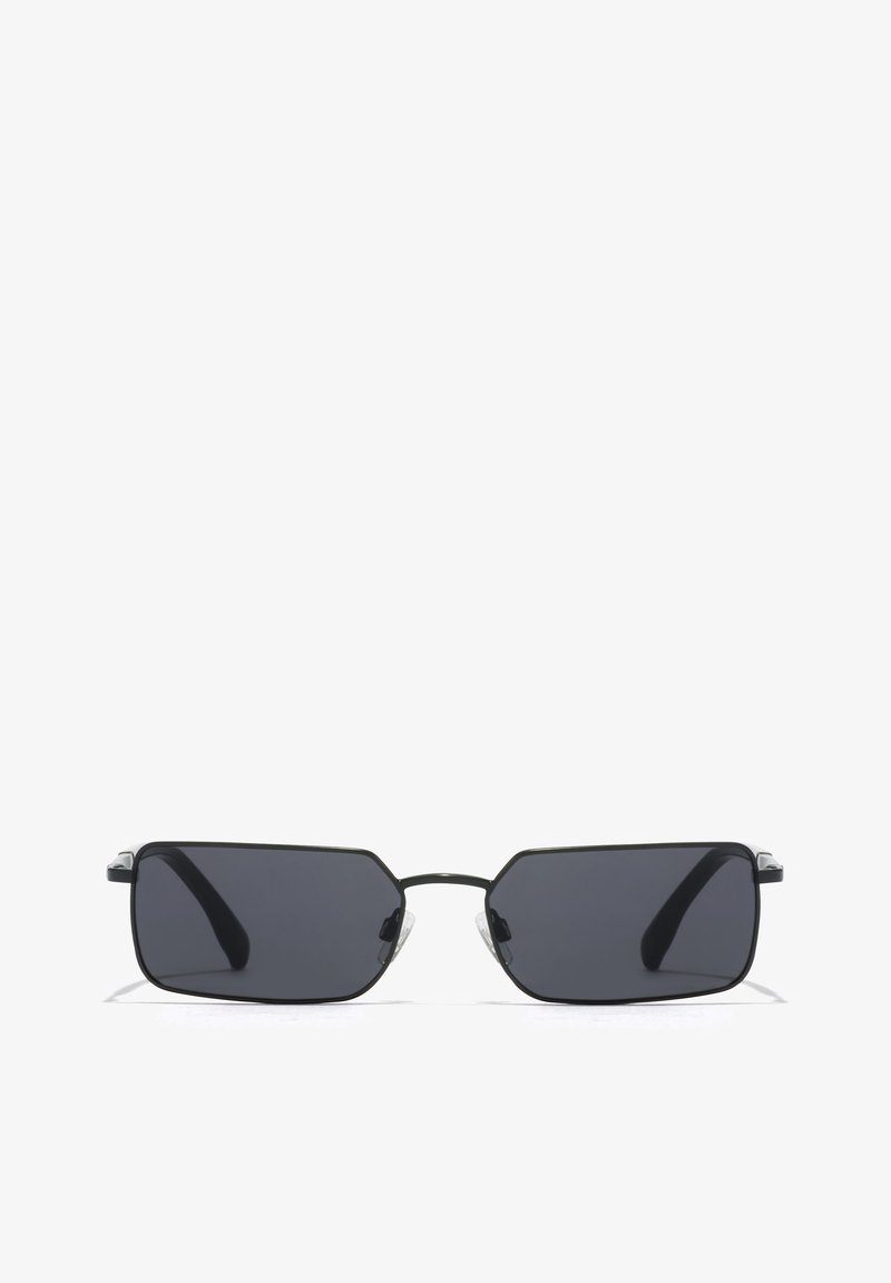 Ochelari de soare negri, rectangulari, cu lentile întunecate, ramă subțire din metal și tampoane nazale transparente. Au colțuri unghiulare și brațe curbe.