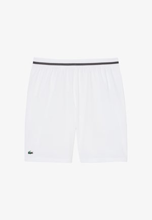 Pantalones cortos con cintura elástica blanca, ribete negro en la pretina y un pequeño logo de cocodrilo verde cerca del dobladillo en la pierna izquierda.