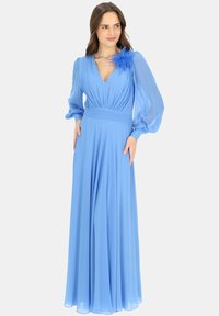 Długa niebieska sukienka z chiffonu z głębokim dekoltem w kształcie litery V, bufiastymi długimi rękawami, plisowanym gorsetem, dopasowanym wcięciem w talii oraz piórowym akcentem na ramieniu.