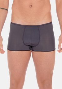 Boxer aderenti neri realizzati in un tessuto liscio e elasticizzato, con una cucitura frontale e una vita rinforzata per maggiore supporto e comfort.