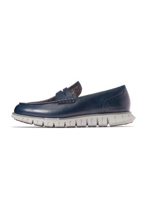 Marineblaue Lederloafer mit akzentuiertem, strukturiertem dunkelblauem Stoff, ausgestattet mit einer flexiblen weißen Gummisohle und dezenten Steppdetails.