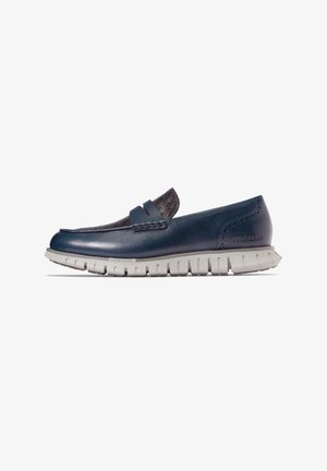Marineblaue Lederloafer mit akzentuiertem, strukturiertem dunkelblauem Stoff, ausgestattet mit einer flexiblen weißen Gummisohle und dezenten Steppdetails.
