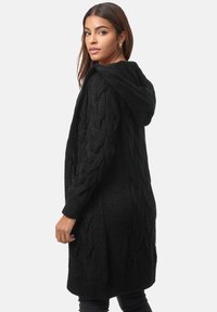 Cardigan nero lavorato a maglia con cappuccio, caratterizzato da un motivo a treccia, maniche lunghe e un design aperto sul davanti.