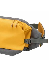 Borsa a vita con una combinazione di colori gialla e grigia. Realizzata in tessuto testurizzato, dispone di un compartimento con zip e una tracolla regolabile per una vestibilità sicura.