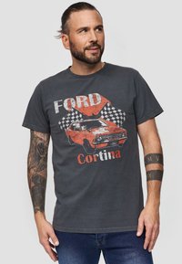 Grå bomulds-t-shirt med et vintage Ford Cortina grafik i orange og rød, med ternede flag og slidte detaljer. Korte ærmer.