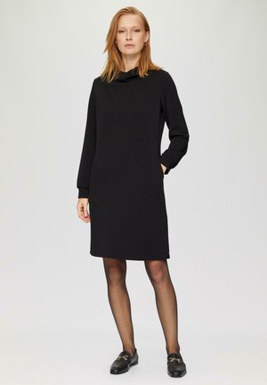 Zwart trui-jurk met een colhals, lange mouwen en zijzakken. Gladde textuur en knielange ontwerp. Draag met zwarte schoenen.