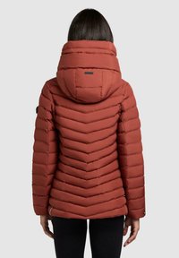 Red puffer jacket with a chevron design, high collar, and hood. Smooth texture with elastic cuffs and contrast hardware details.