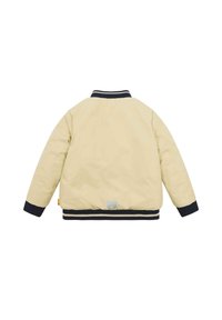 Cremfarbende Jacke mit glatter Textur, gerippten marineblauen Bündchen und Saum sowie einem kleinen Bärenlogo auf der Rückseite nahe dem Saum. Einfaches Design.