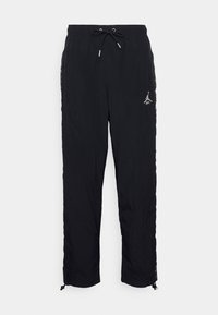 Black windbreaker pants with elastic waistband, adjustable drawstring, and zippered ankle cuffs. Features logo on the left leg.