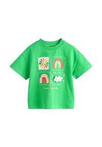 Camiseta de algodón verde con cuatro parches gráficos coloridos: sol, arcoíris y una nube con detalles texturizados. Cuello redondo y mangas cortas.