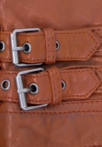 Brauner Lederarmband mit zwei silbernen Metallschnallen und Ösen; strukturierte Oberfläche mit sichtbaren Nähten und Akzenten zur Anpassung.