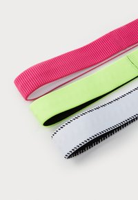 Tre elastici per capelli: rosa con texture a righe, verde neon liscio e un elastico bianco con dettagli di cucitura nera.