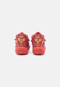 Czerwone buty do koszykówki z teksturowanym wzorem, złotymi akcentami i wysokim kołnierzem. Posiadają wyraźne logo oraz gumową podeszwę zapewniającą przyczepność.