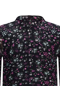 Schwarze Bluse mit Floral-Design, die eine Netztextur aufweist und mit rosa, blauen und weißen Blumen verziert ist. Stehkragen und lange Ärmel. Überall gemustert.