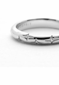 Silberring mit einer glatten, polierten Oberfläche, die sternförmige Akzente und kleine Edelsteine zwischen ihnen hat. Einfaches, kreisförmiges Design.