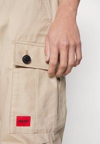 HUGO GARLO - Oldalzsebes nadrágok - medium beige