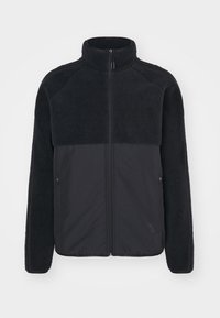 Black jacket featuring a fuzzy, textured upper section with a smooth, contrasting lower half. High collar and side zip pockets included.