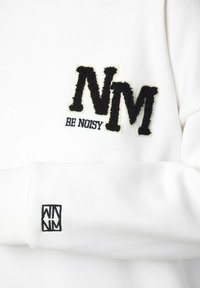 Witte sweatshirt met textuurvolle zwarte borduursels van de teksten "NM" en "BE NOISY". De manchetten tonen een kleiner zwart logo. Zachte stof.