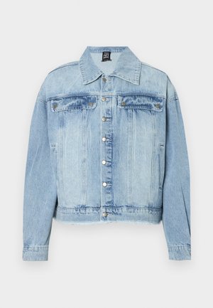 Casaco de denim azul claro com colarinho clássico, fecho frontal com botões, dois bolsos no peito e uma bainha ligeiramente desfiada. A textura do denim é visível.